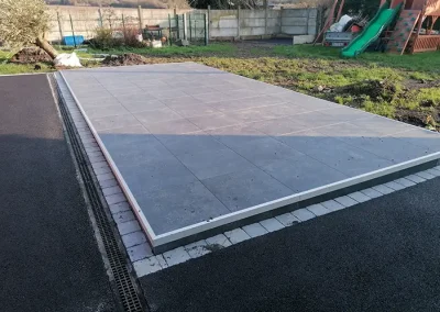 photo d'une terrasse sur plot avec une allée en pierre bleue réalisée par SG Aménagement